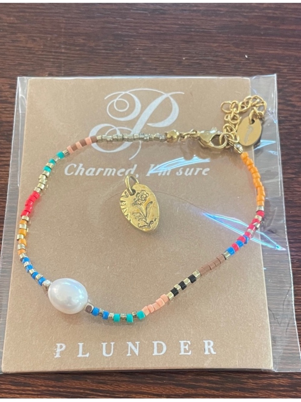 Plunder Bracelet + Charm Set.
Pearl beaded bracelet. Gold rose charm. New in bag